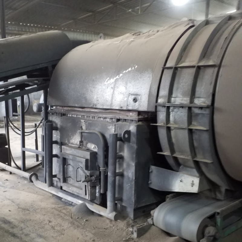 Vista de caldeira industrial robusta, instalada em ambiente protegido por grades, necessitando de inspeção e manutenção conforme normas NR13.