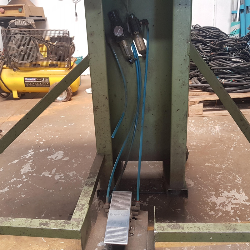 Vista detalhada de sistema de compressão industrial, incluindo compressor amarelo e tubulações azuis, necessitando de inspeção e manutenção conforme normas NR12.