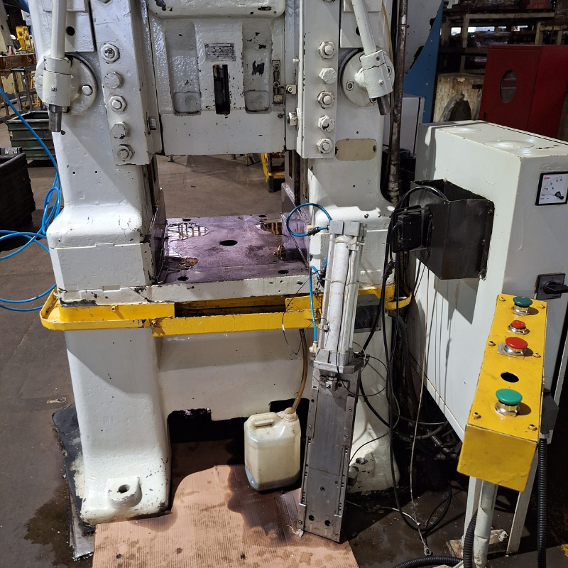Vista detalhada de máquina industrial de processamento com componentes mecânicos e elétricos visíveis, necessitando de inspeção e manutenção conforme normas NR12.