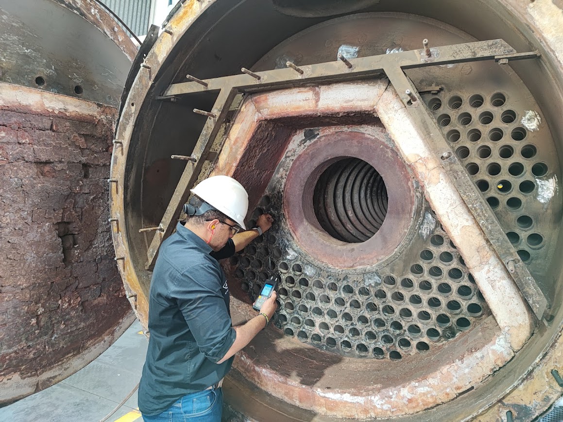 Engenheiro realizando análise detalhada em caldeira industrial para laudo NR13.