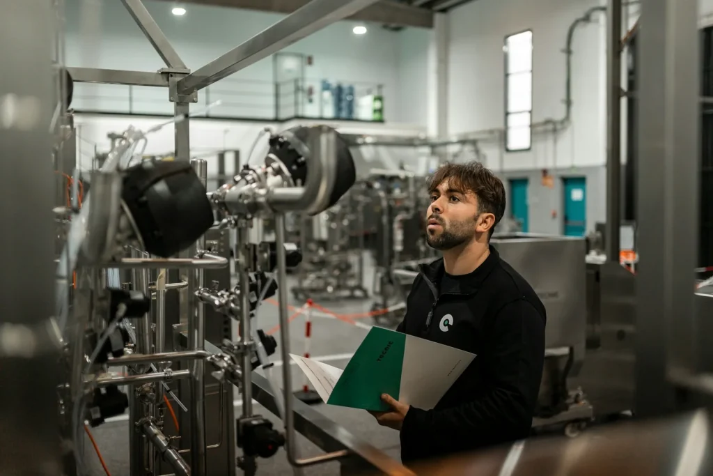 Especialista inspeciona máquina industrial para responder dúvidas frequentes sobre a NR-12