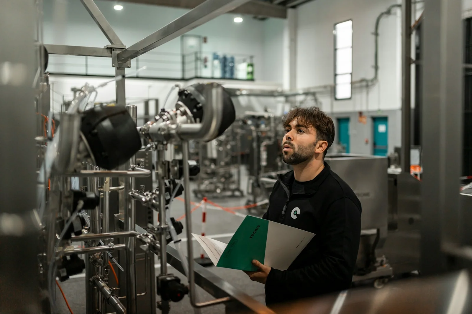 Especialista inspeciona máquina industrial para responder dúvidas frequentes sobre a NR-12