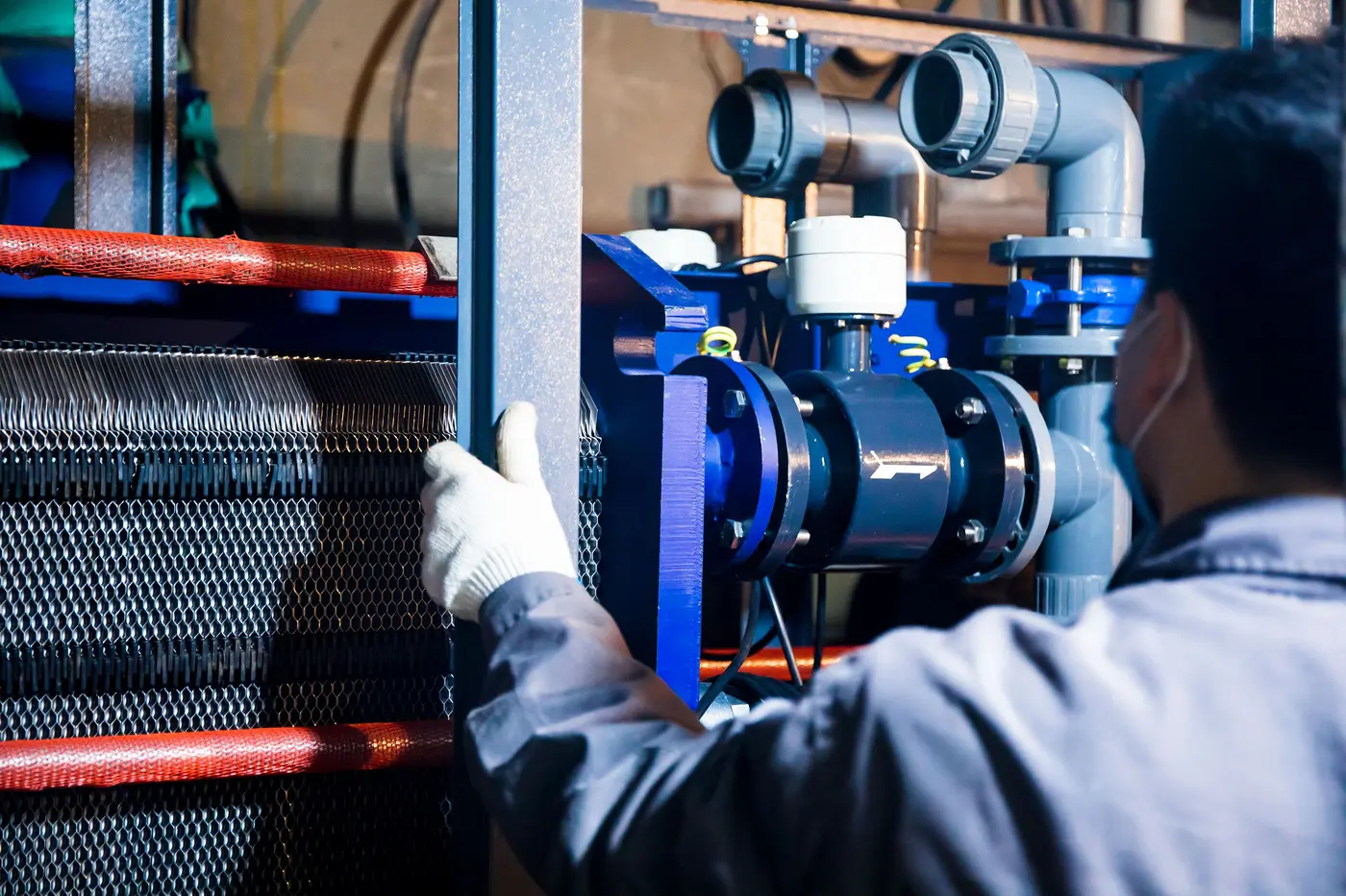 Profissional inspecionando equipamento industrial com tubulações
