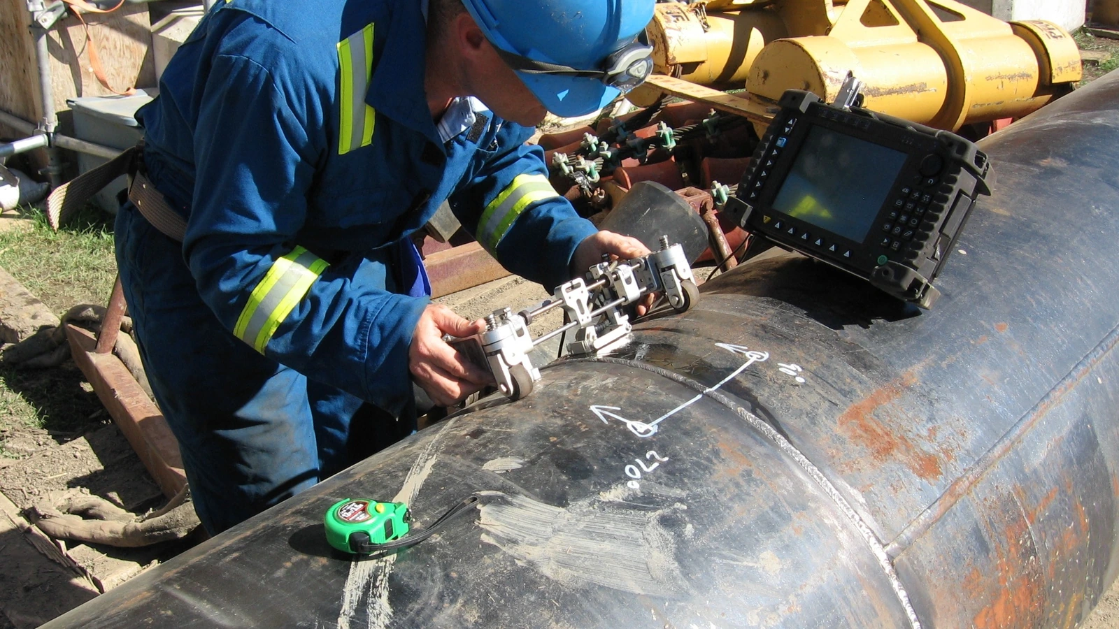 Profissional realizando ensaio ultrassônico em tubulação industrial