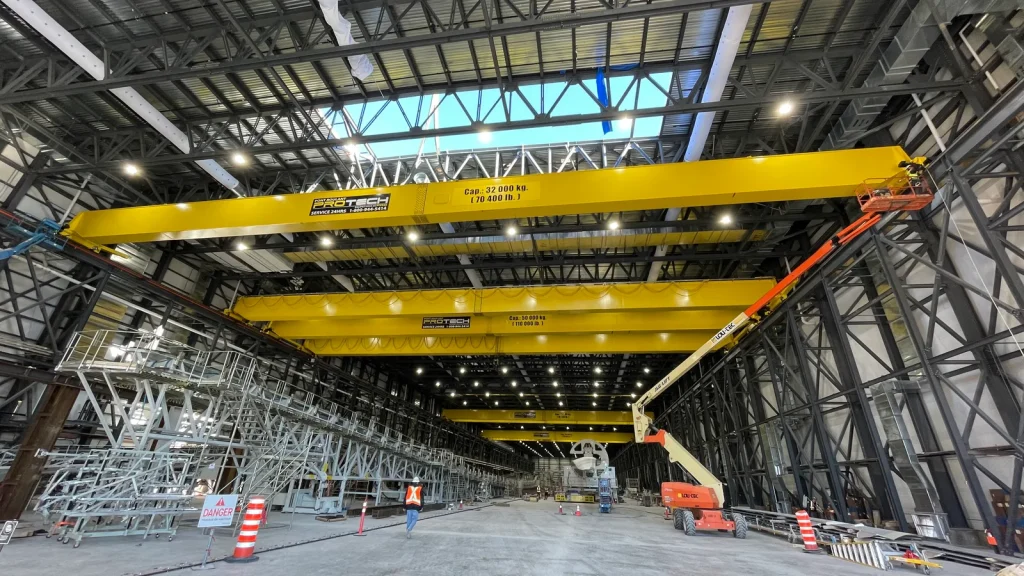 Pontes rolantes amarelas instaladas no interior de um galpão industrial