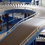Sistema de correias transportadoras azuis instalado em área industrial automatizada
