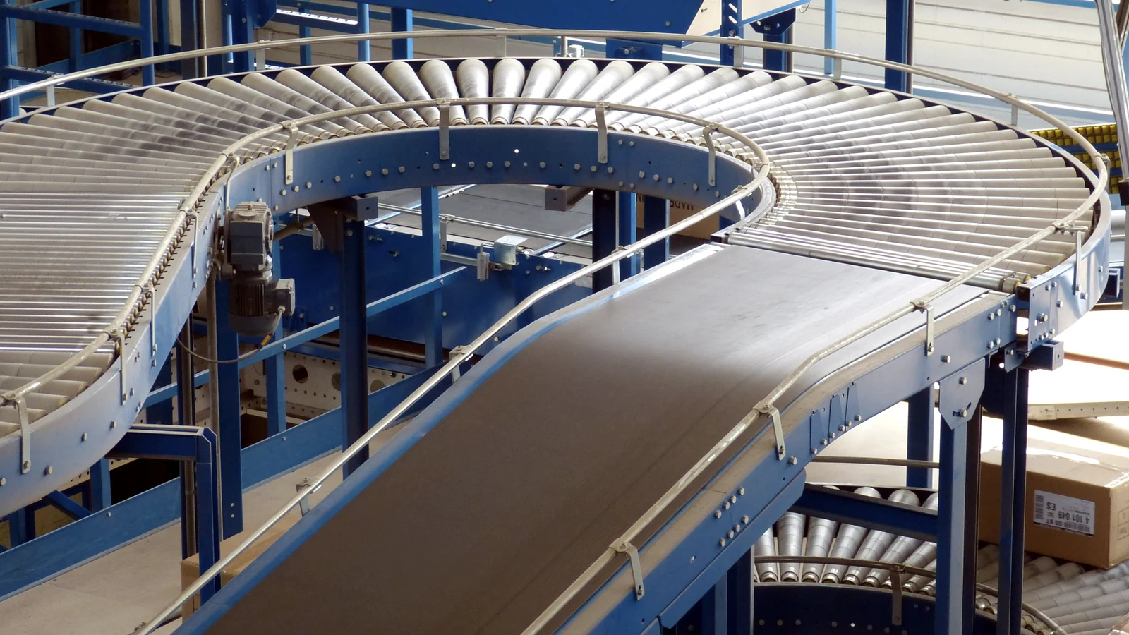 Sistema de correias transportadoras azuis instalado em área industrial automatizada
