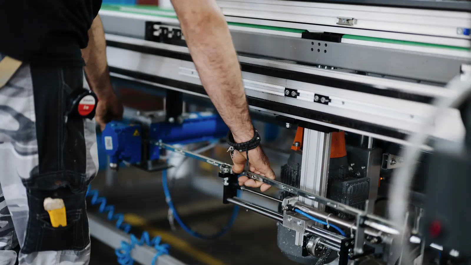 Profissional realiza ajuste mecânico em equipamento industrial durante manutenção