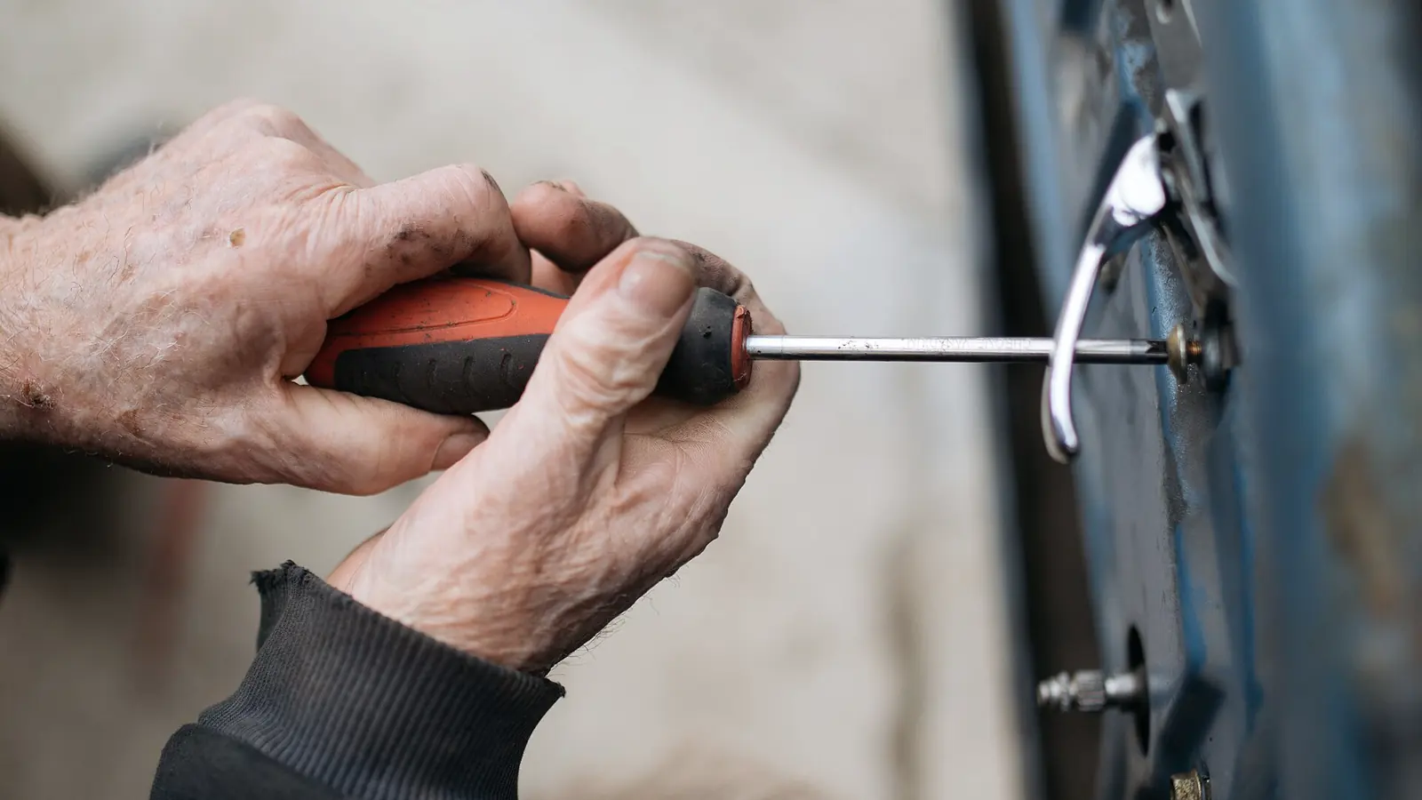 Mãos de profissional usando ferramenta para ajustar componente de máquina industrial