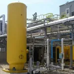 Vaso de pressão vertical em planta industrial inspecionado por empresa de NR13 para garantir segurança e conformidade.
